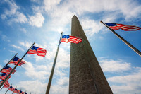 The sun shines through flags around the Washington Monument in Washington DC