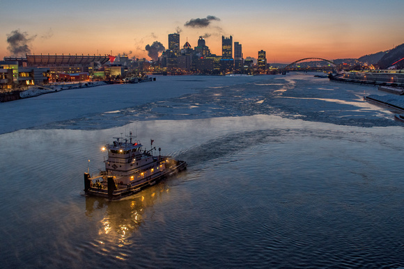 A barge on the icy waters of the Ohio River at dawn