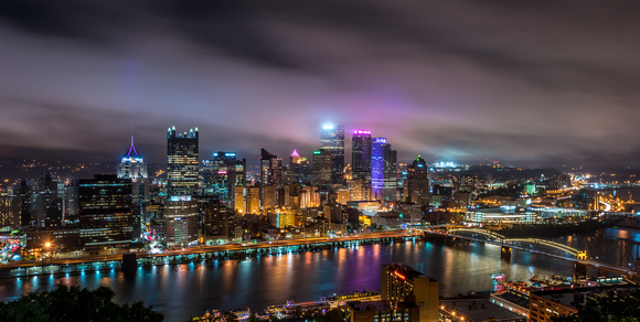 Downtown Pittsburgh glows beneath cloudy skies