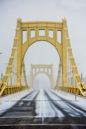 The snowy Clemente Bridge leads into a squall in Pittsburgh