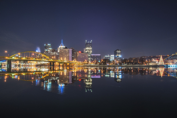 Pittsburgh skyline and Christmas tree reflect in the Allegheny River