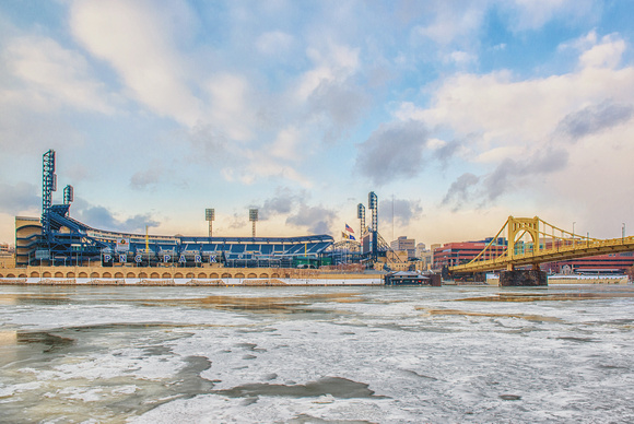 PNC Park and Clemente Bridge on a sunny afternoon by the icy Allegheny River in Pittsburgh