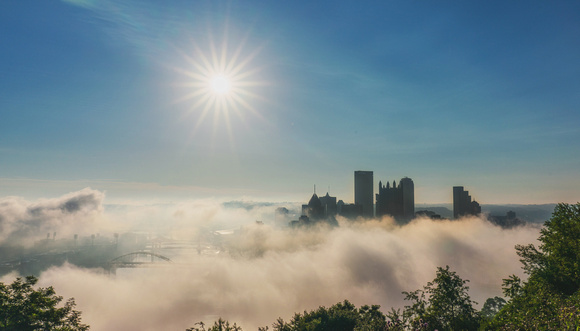 The sun shines over a foggy morning in Pittsburgh