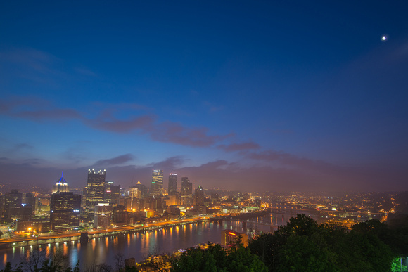 Moon over a purple Pittsburgh skyline before dawn