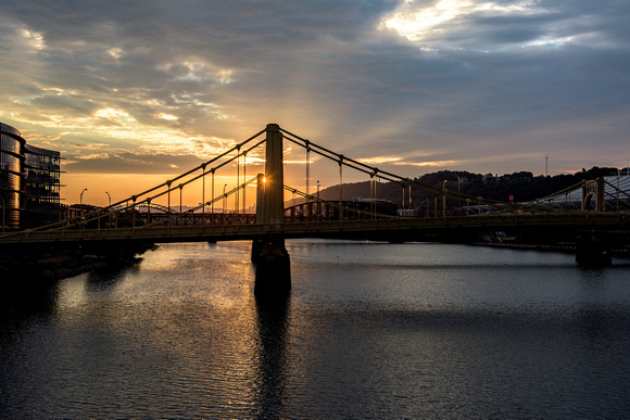 The sun shines through the Sister Bridges at dawn in Pittsburgh