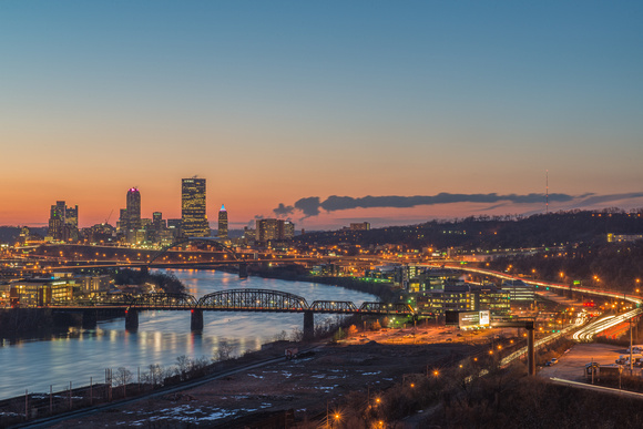 Light trails move around Pittsburgh on the Monongahela River at dusk
