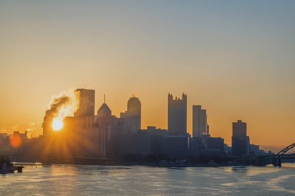 A sunflare through the Pittsburgh skyline from the West End Bridge