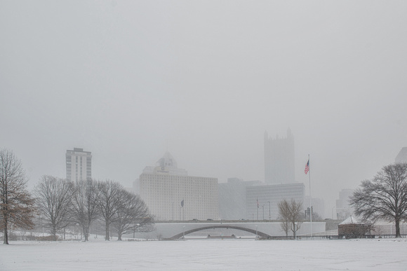 The Pittsburgh skyline can be seen through a snow storm from Point State park