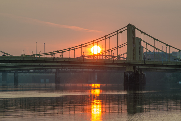 The sun rises in Pittsburgh between the Sister Bridges