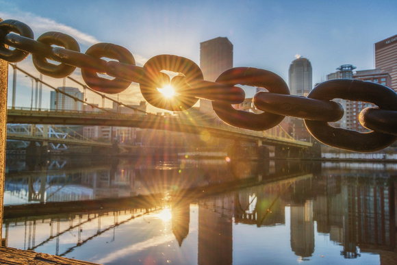 The sun shines through a chain on the North Shore and reflects in the Allegheny River HDR