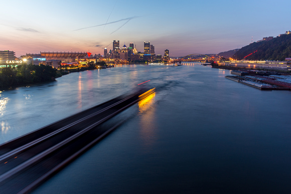 Barge zips along the Ohio River in Pittsburgh at dawn