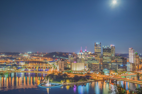 A bright moon over the Giant Rubber Duck and Pittsburgh