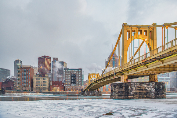 A straight on view of the Robreto Clemente Bridge in Pittsburgh during winter on the iced over Allegheny River