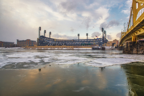 A break in the snow opens above PNC Park in Pittsburgh by the iced over Allegheny River