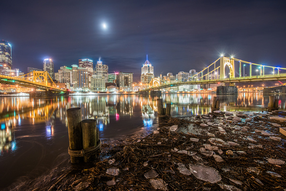 The moon reflecting in a high Allegheny River in Pittsburgh