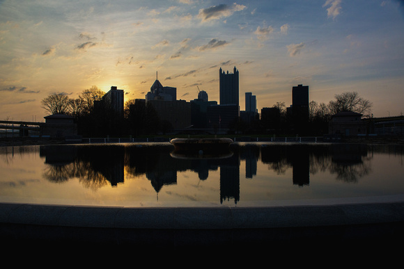 Pittsburgh skyline silhouettes reflects at dawn in the fountain pool at Point State Park
