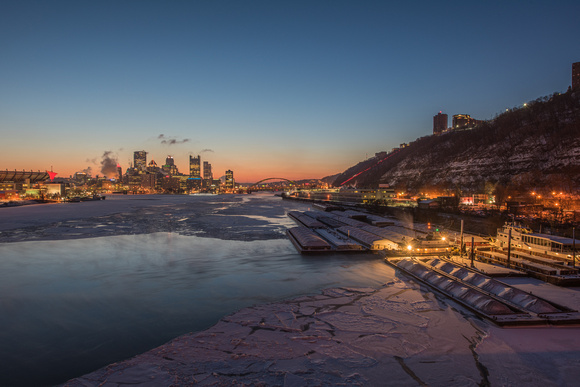 Downtown Pittsburgh glows over the Ohio River before sunrise