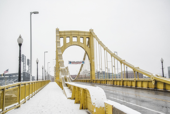 A snowy walkway along the Roberto Clemente Bridge in Pittsburgh