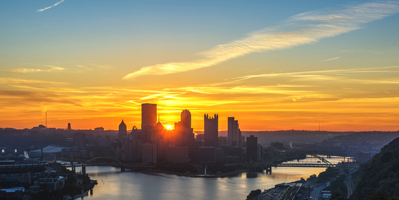 The sun sits in the Pittsburgh skyline at dawn