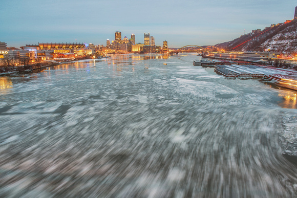 A long exposure of ice rushing under the West End Bridge in Pittsburgh