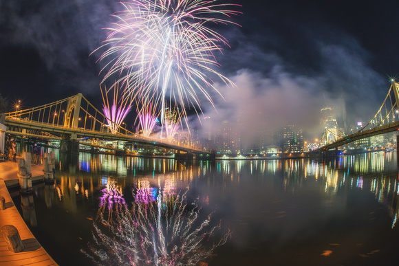 Fireworks reflect in the river in Pittsburgh during Light Up NIght