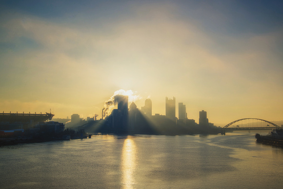 The sun rises at dawn over Pittsburgh from the West End Bridge