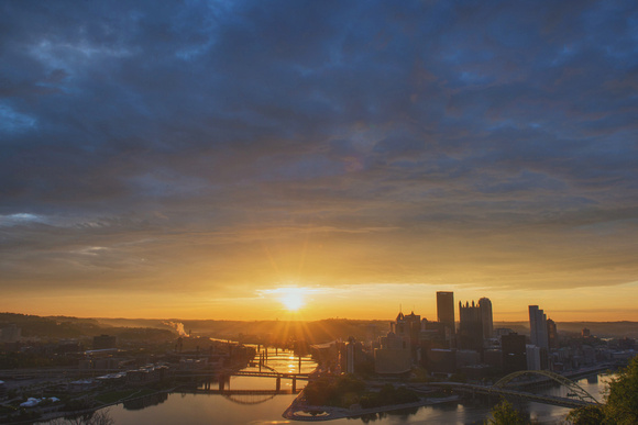 Sun coming through the clouds over Pittsburgh at dawn