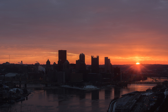 Pittsburgh is silhouetted against a bright sunrise