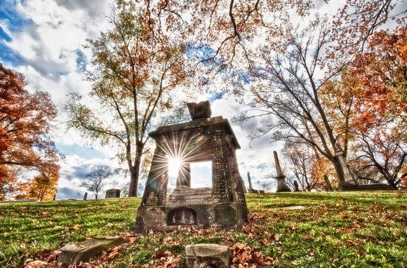 Sunflare through a tombstone at Allegheny Cemetery HDR