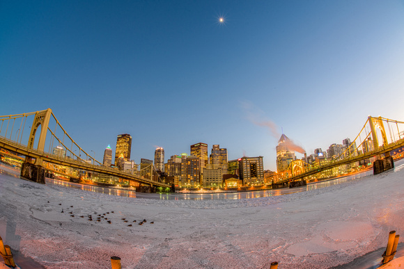 Fisheye view of the moon over the Pittsburgh skyline in the winter