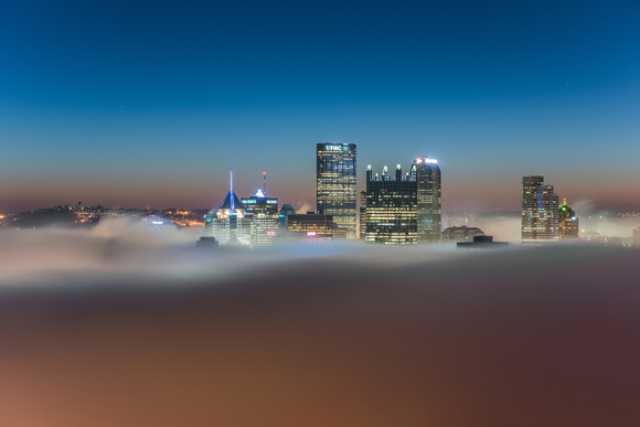 The Pittsburgh skyline rises above the fog before dawn