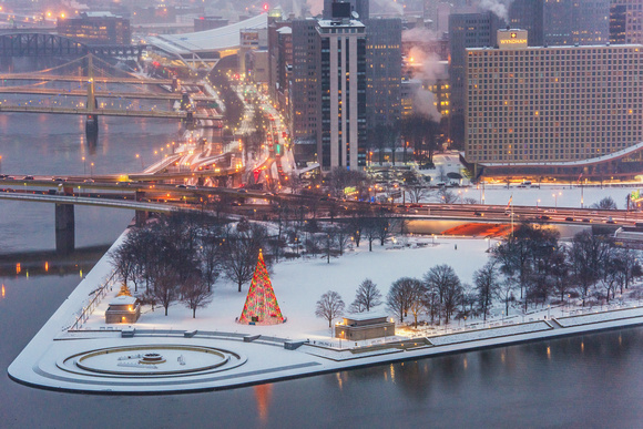 The Christmas tree at Point State Park shines in the snow in Pittsburgh