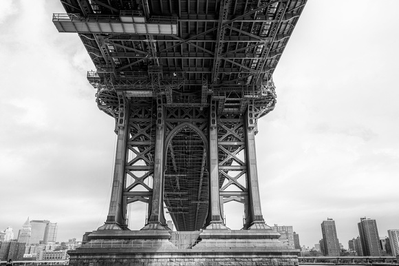 A black and white view under the Manhattan Bridge